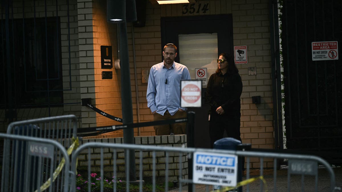 Security guards stand outside a brick building