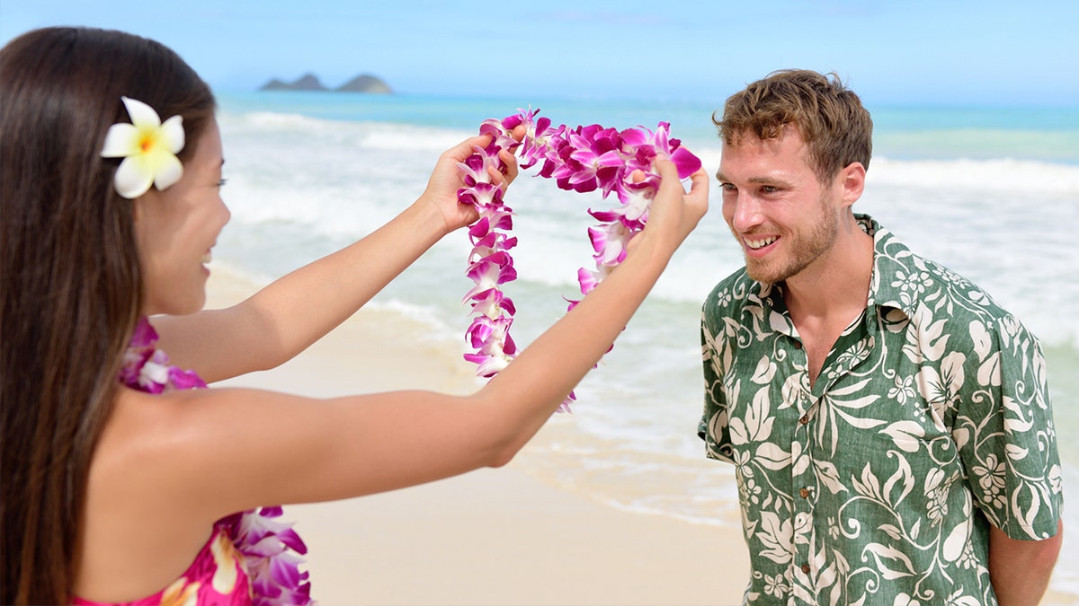 Hawaii woman giving lei garland welcoming tourist