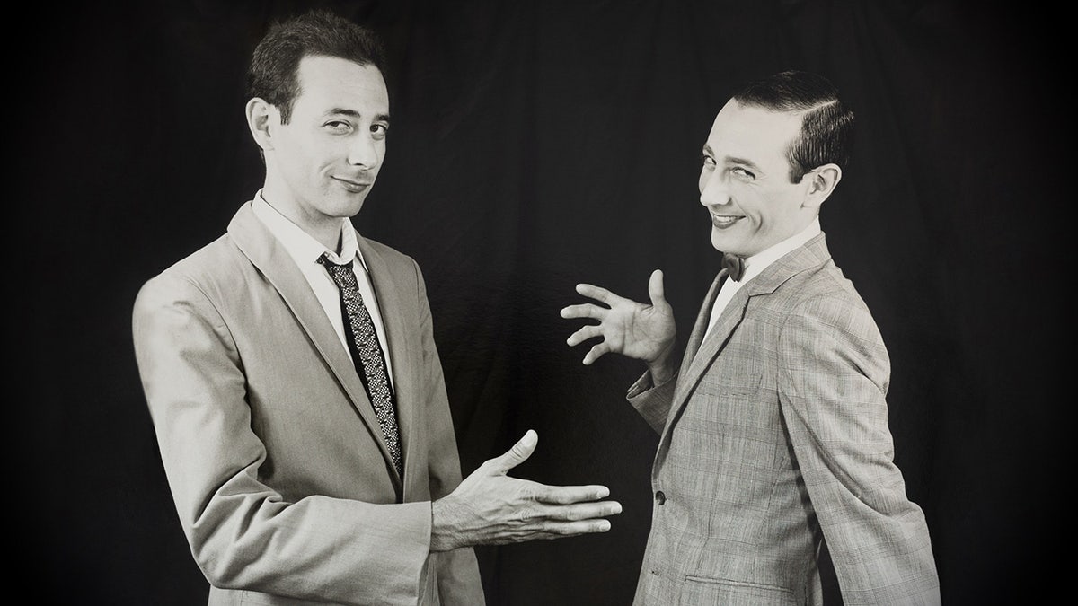 Paul Reubens attempting to shake his own hand.