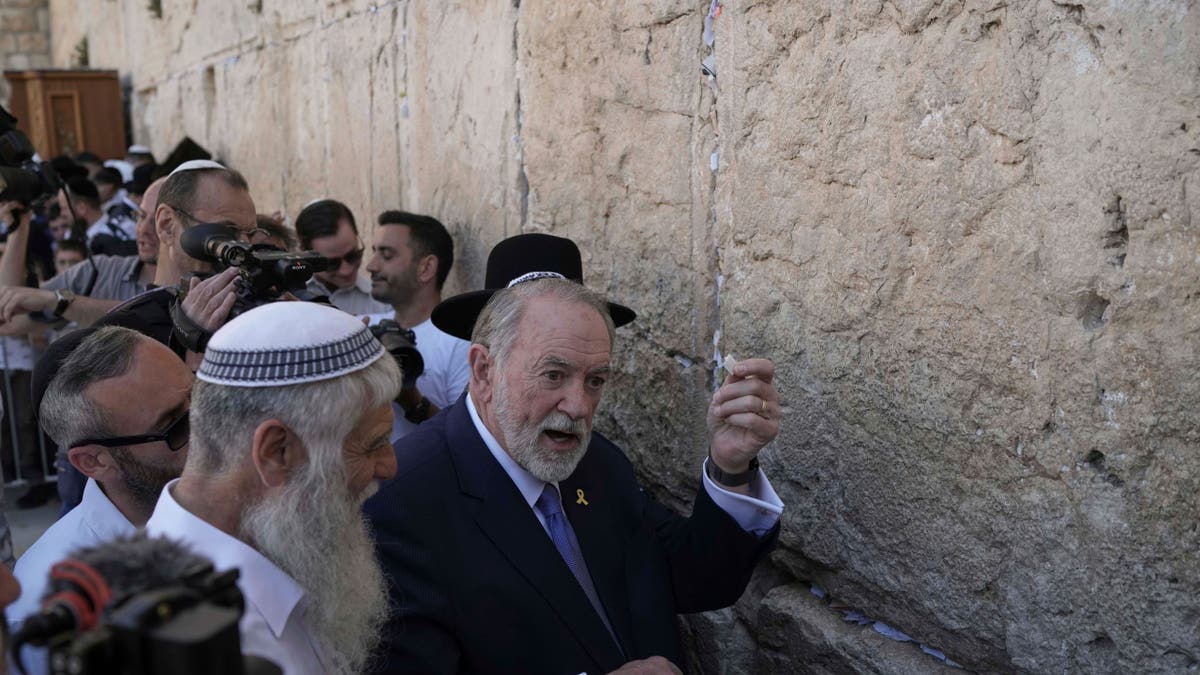 The U.S. ambassador to Israel, Mike Huckabee, holds a note given to him from President Donald Trump to be placed in the cracks of the Western Wall, the holiest site where Jews can pray, in the Old City of Jerusalem, Friday, April 18, 2025.