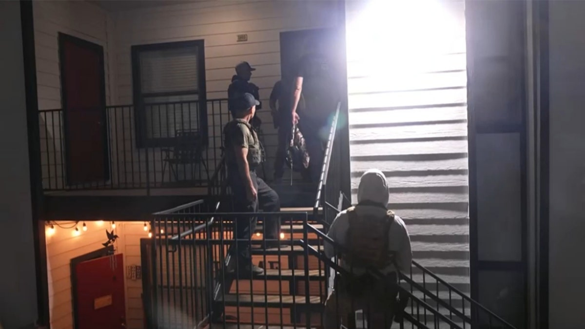 law enforcement approach door of an apartment