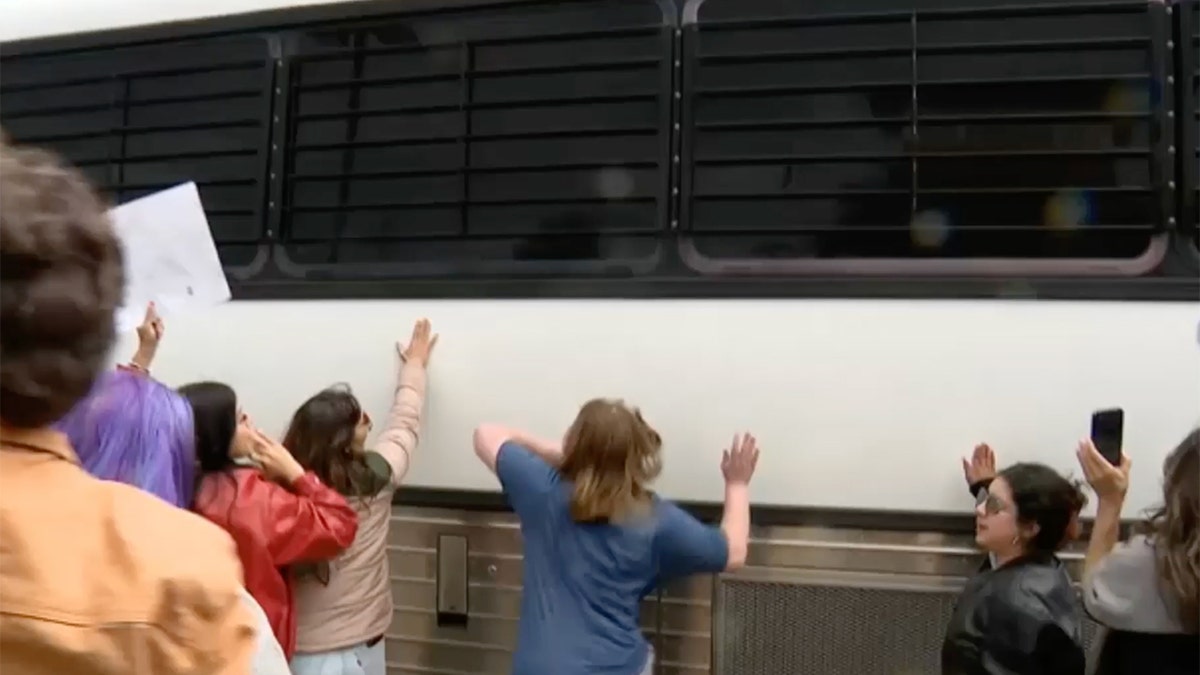 Protesters slam on a bus carrying ICE detainees.