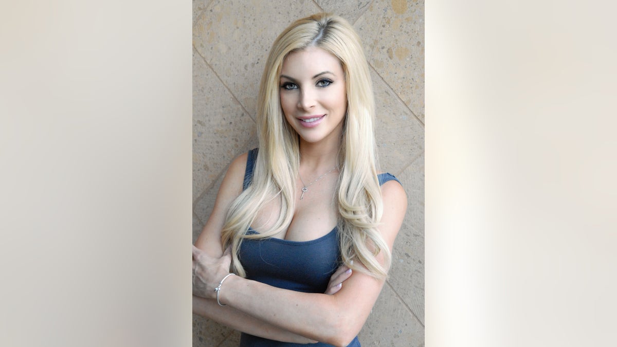 Kimberly Fattorini wearing a blue top with her arms crossed.