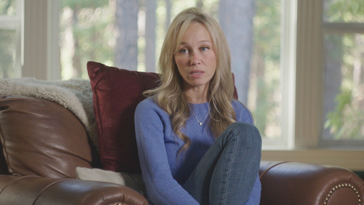 A close-up of Sherri Papini wearing a periwinkle sweater and jeans sitting on a couch.