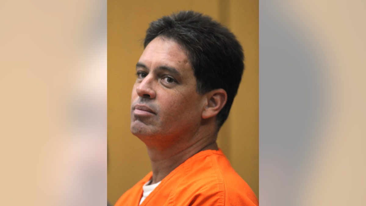 A close-up of Leo Schofield in an orange jumpsuit.
