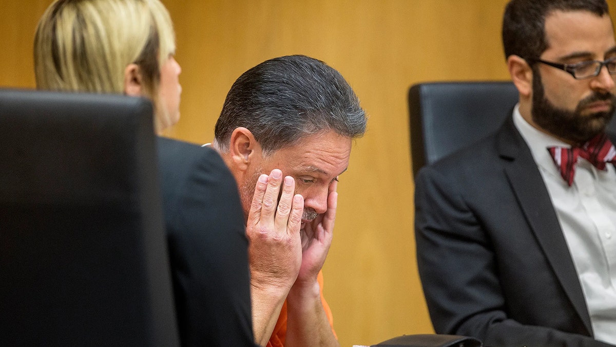Leo Schofield with his hands to his face in court.