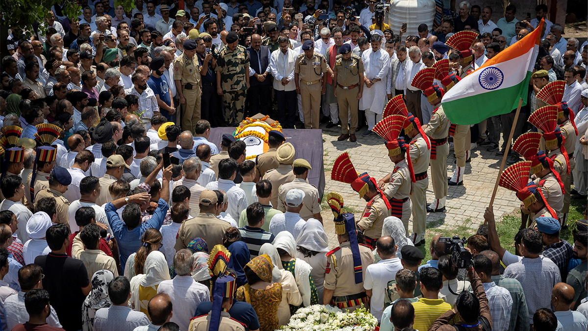 Indian policemen pay their respects during a funeral