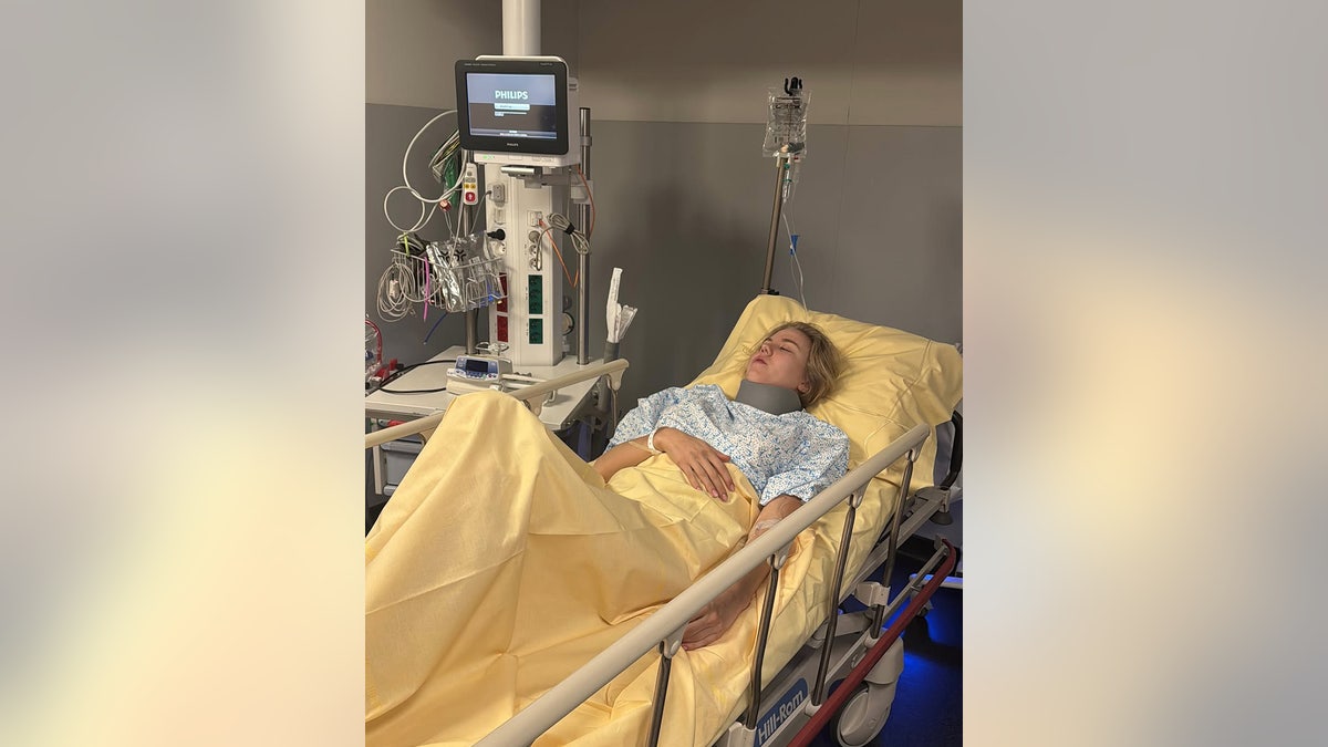Princess Maria Carolina laying on a hospital bed wearing a neck brace.