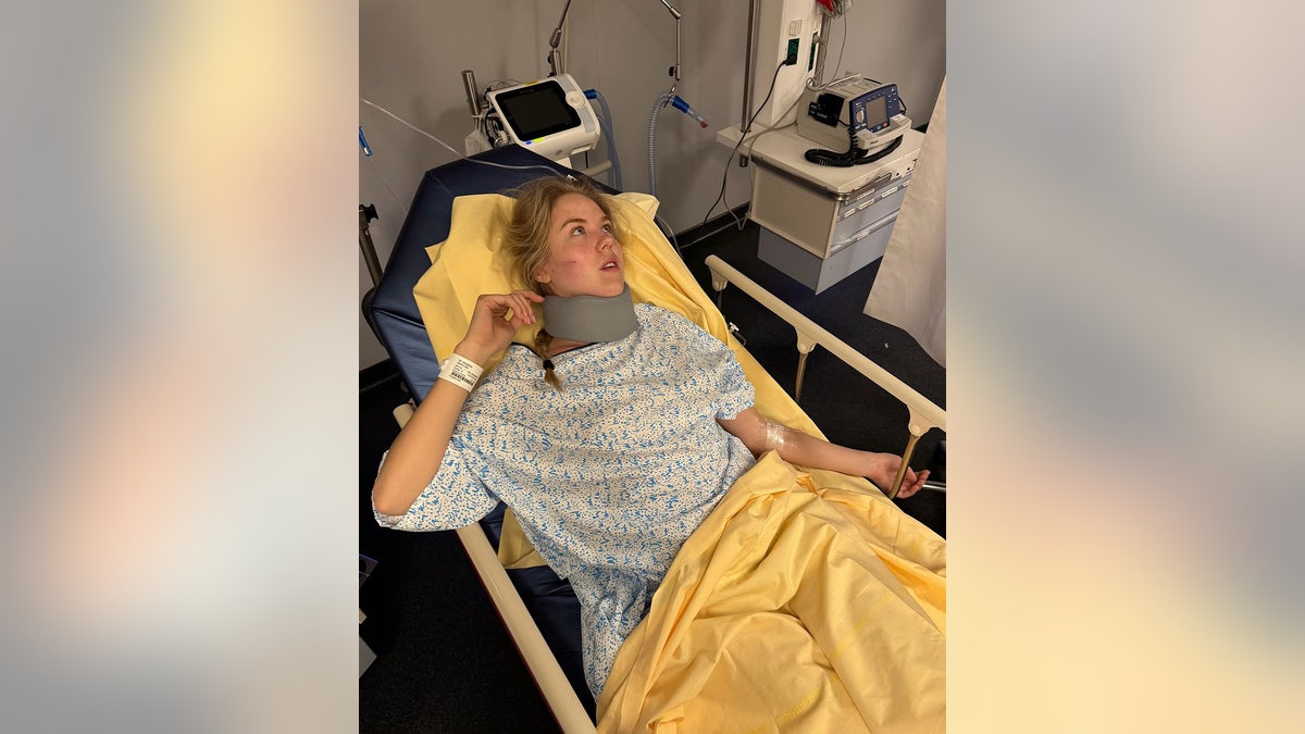 Princess Maria Carolina with a neck brace laying at a hospital bed.