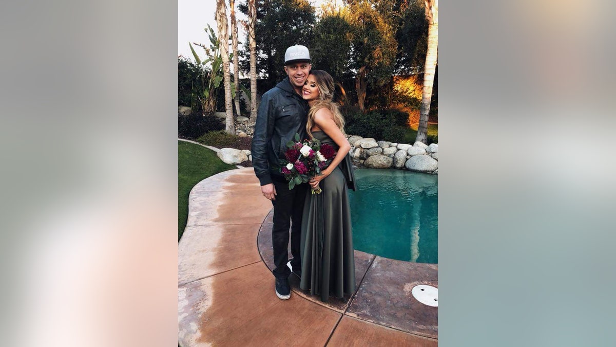 James Kulstad being embraced by a female adjacent a pool.