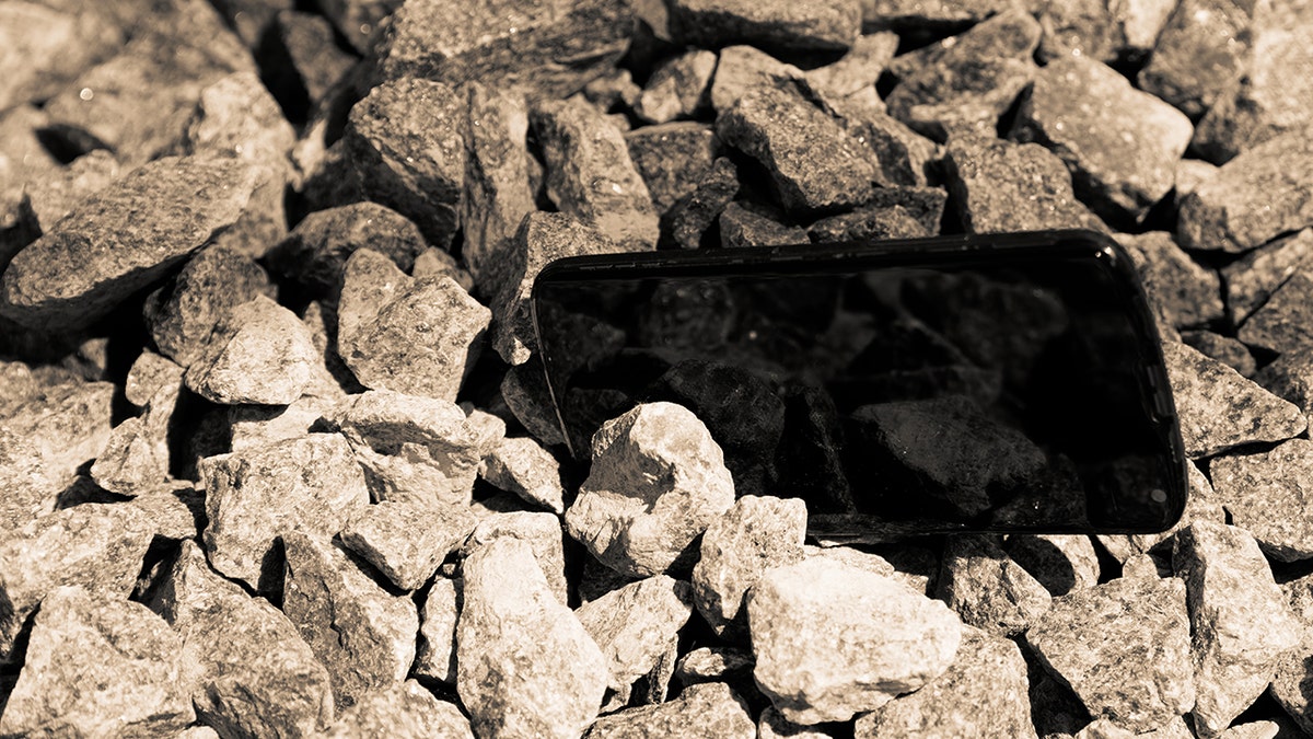 Lost memories may be recovered as woman finds phone in Hurricane Helene landslide ruins Broken cellphone abandoned and lost among the gravel. Used in story about woman recovering phone from rubble following the aftermath of Hurricane Helene.