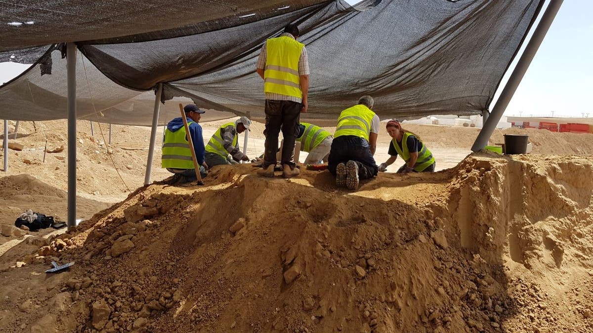 Excavators working at mound