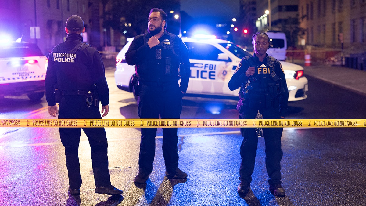 Metropolitan Police Department and Federal Bureau of Investigation officers stand guard at a perimeter near the Capital Jewish Museum