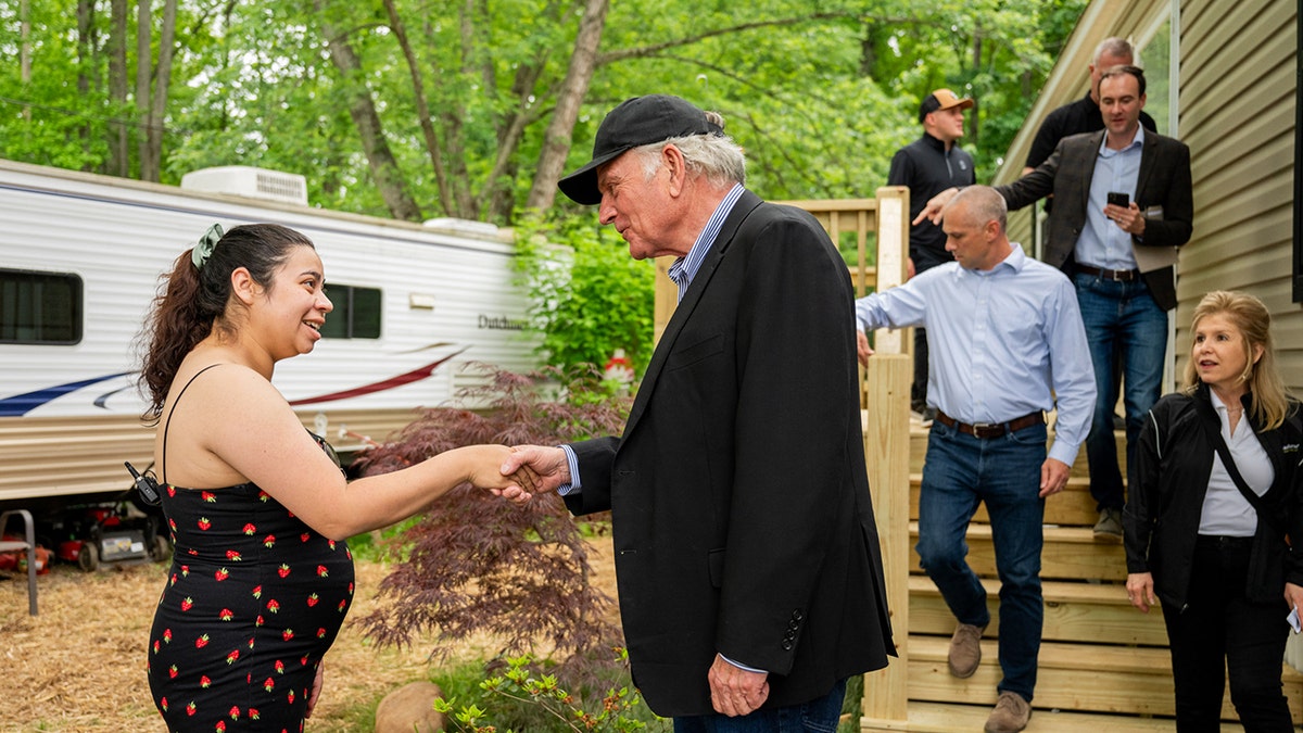 Franklin Graham shakes hands with a mother outside her new Samaritan’s Purse-donated mobile home in Swannanoa, N.C.