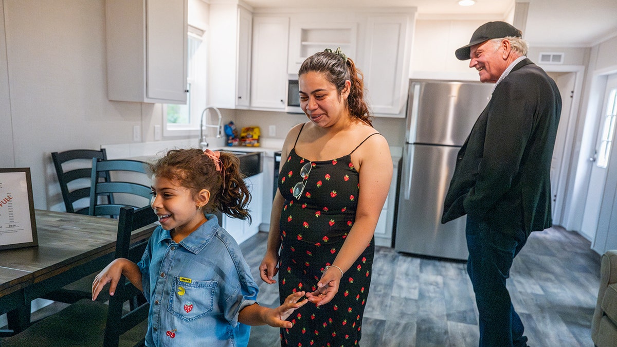 A young girl and her mother walk into their new home with Franklin Graham during a Samaritan’s Purse dedication
