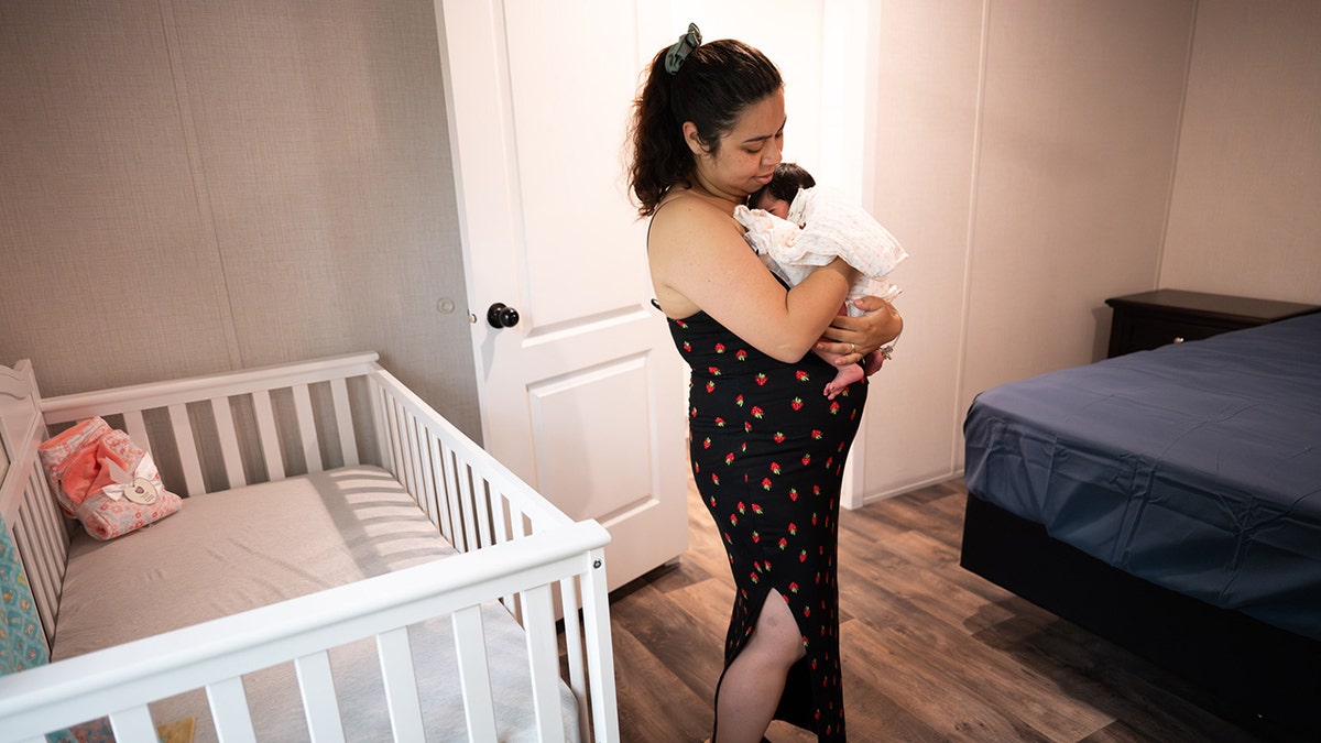 Mother cradles newborn baby in nursery of her new Samaritan’s Purse home after being displaced by Hurricane Helene