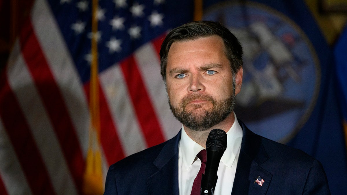 JD Vance standing in front of American flag