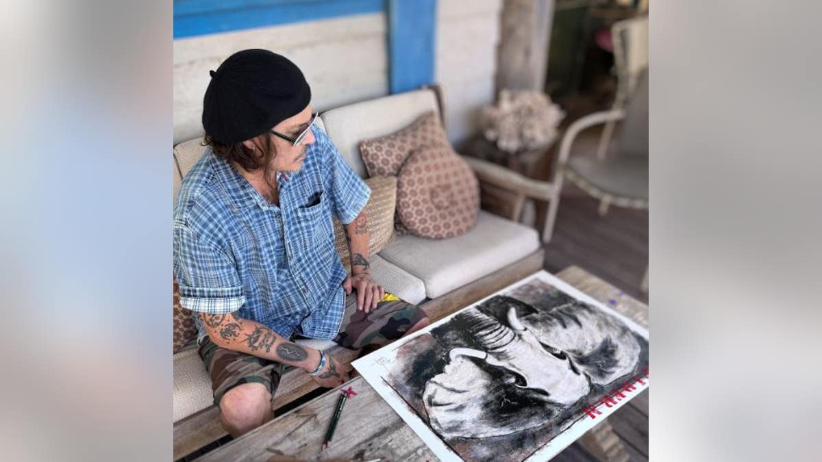 Johnny Depp looking at elephant drawing