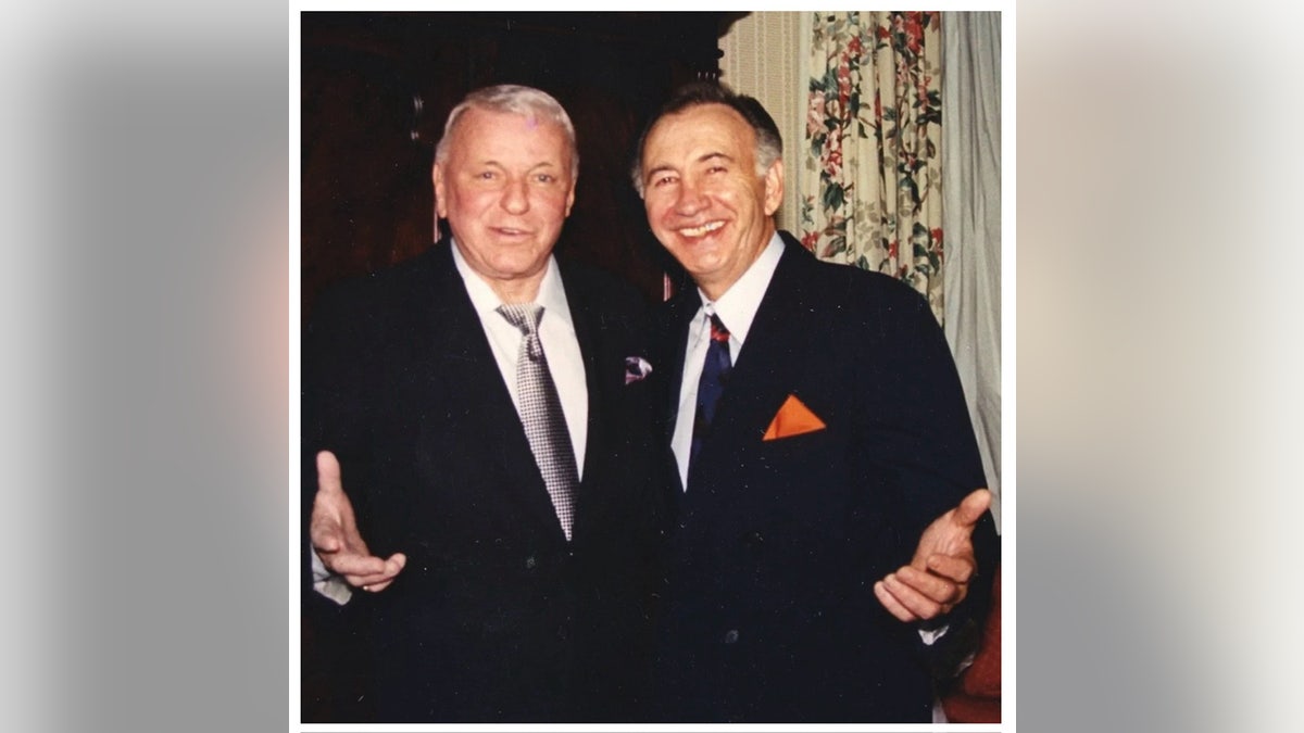 Joseph Paris and Frank Sinatra wearing matching suits and posing for the camera.