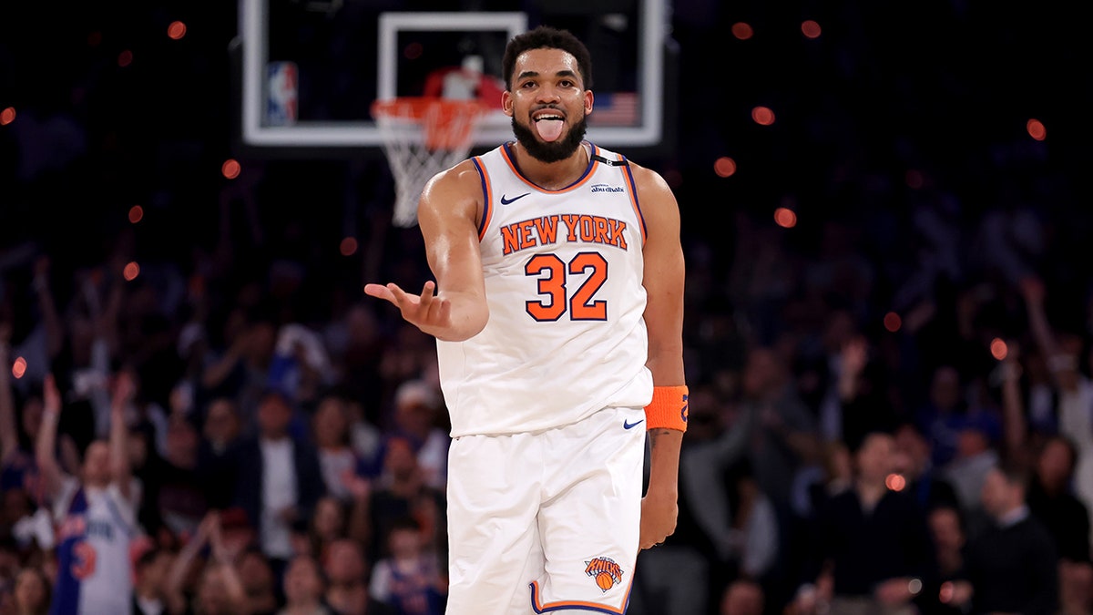 New York Knicks center Karl-Anthony Towns celebrates after making a three-point shot during a basketball game.