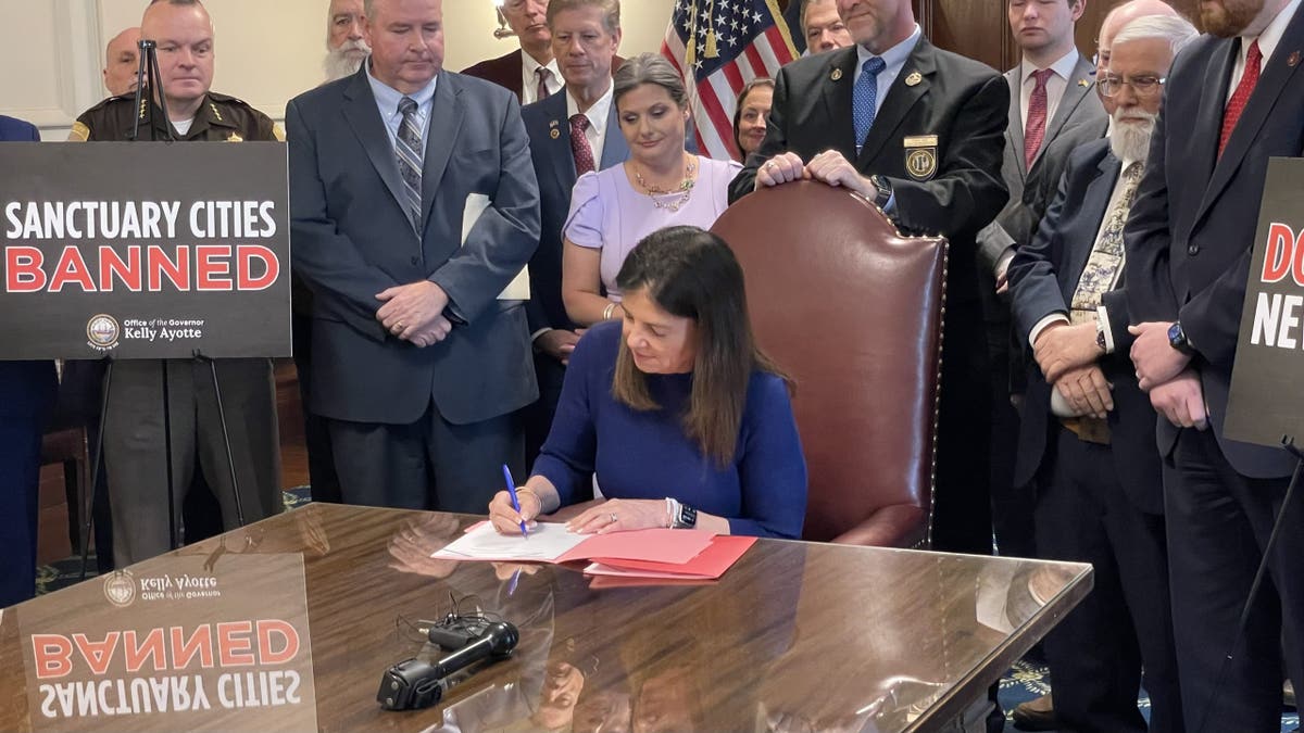 Republican Gov. Kelly Ayotte of New Hampshire signs into law two bills that ban sanctuary cities, at the Statehouse in Concord, N.H., on May 22, 2025.