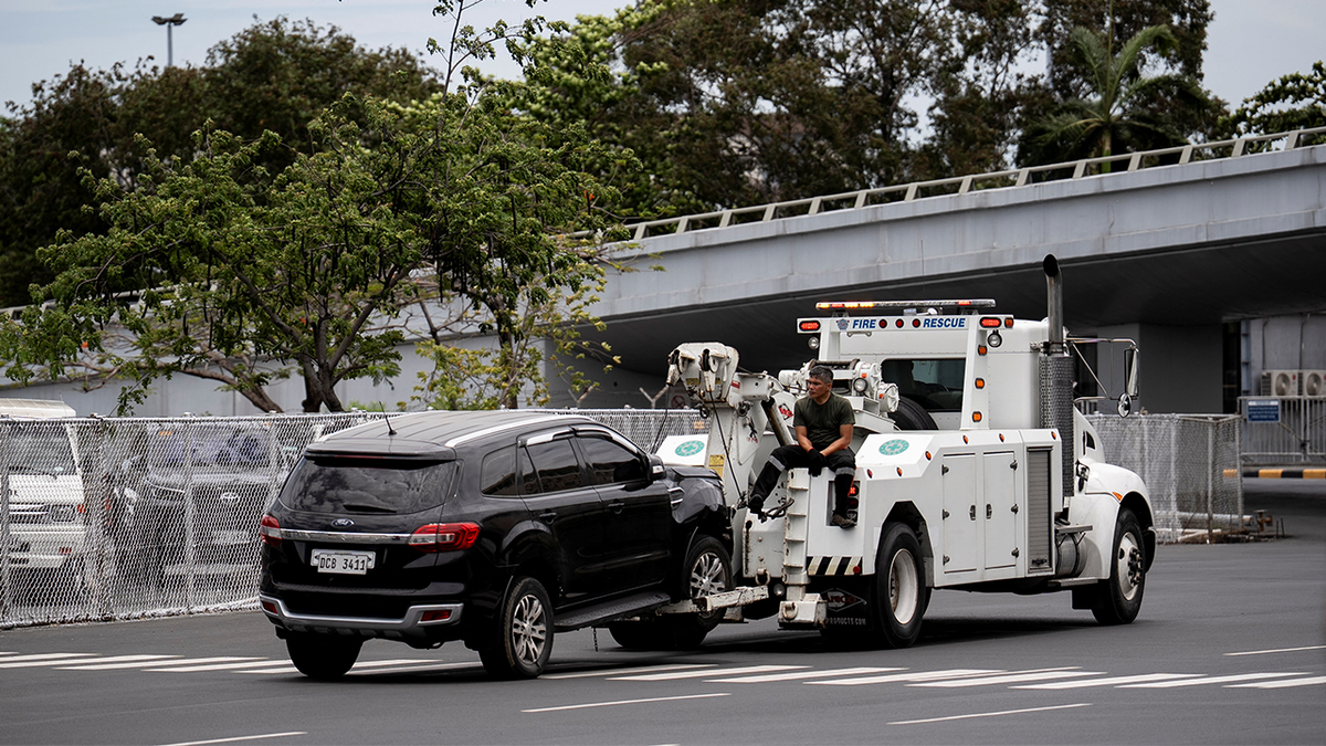 Workers tow the vehicle that crashed into the entrance of Ninoy Aquino International Airport Terminal 1
