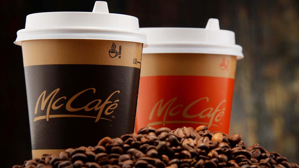 Two McCafé cups from McDonald's are shown on a mound of coffee beans.