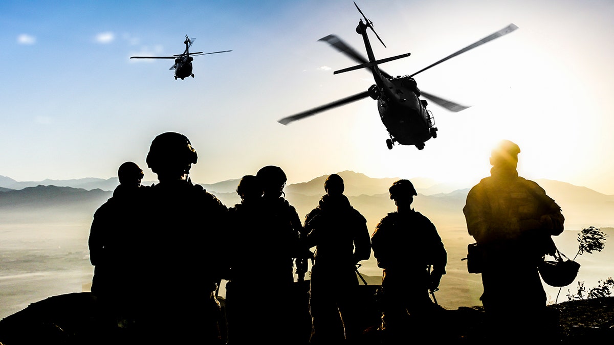 Silm from the soldiers during the military mission at dusk, helicopters fly in the area while the sun's rays reach the peak through the mountains in the distance
