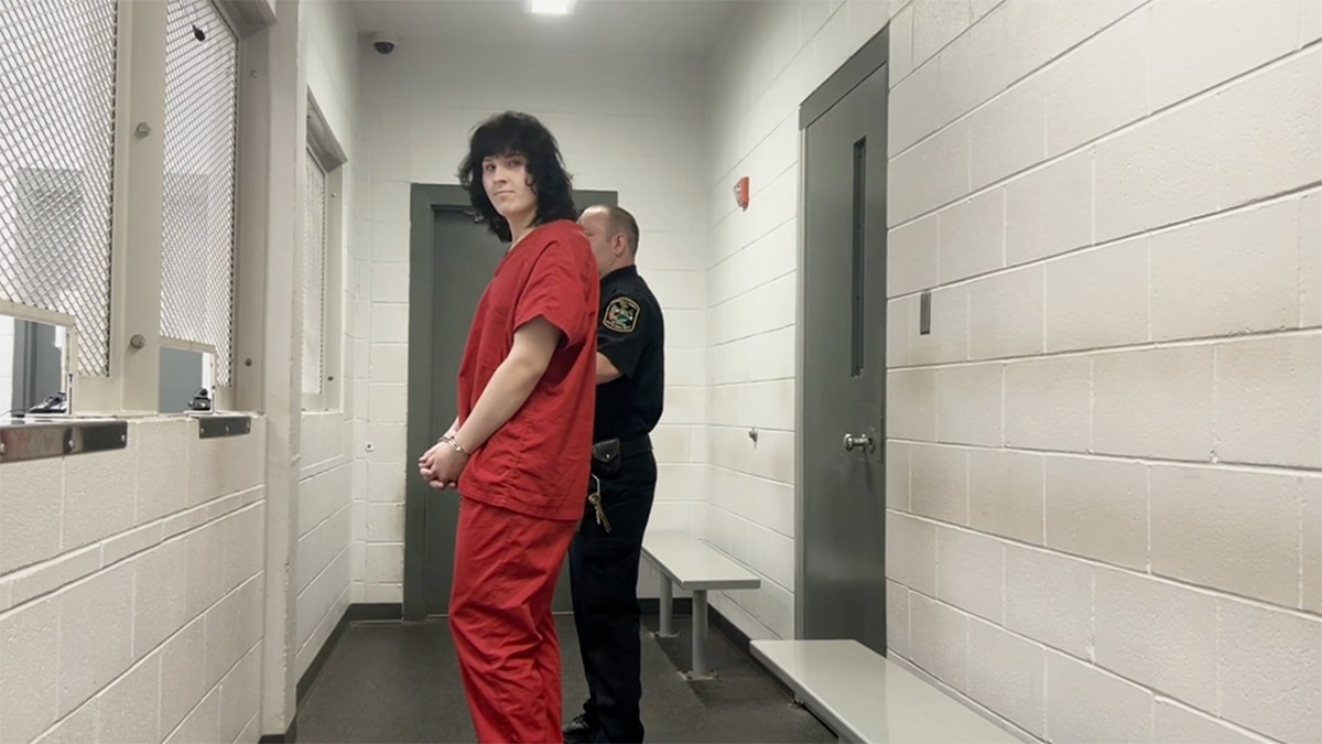 Samuel Theodore Cain in an orange jail uniform is escorted by an officer inside the Greenville County Detention Center