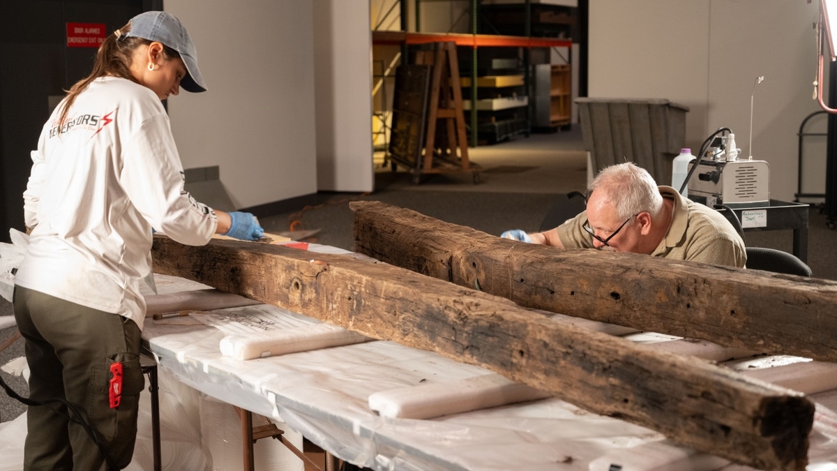 Museum officials restoring wooden beams