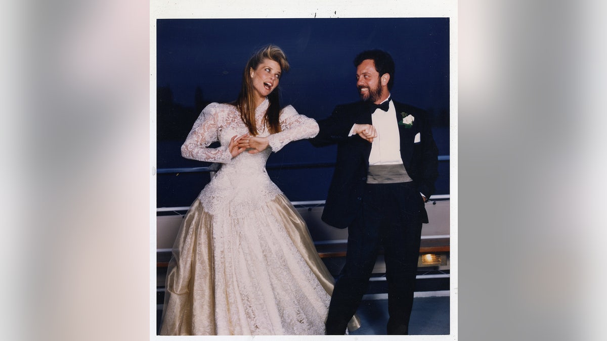Christie Brinkley and Billy Joel posing playfully on their wedding day.