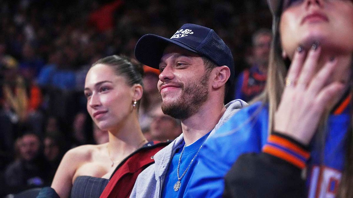 Pete Davidson smiling while watching a Knicks basketball game.