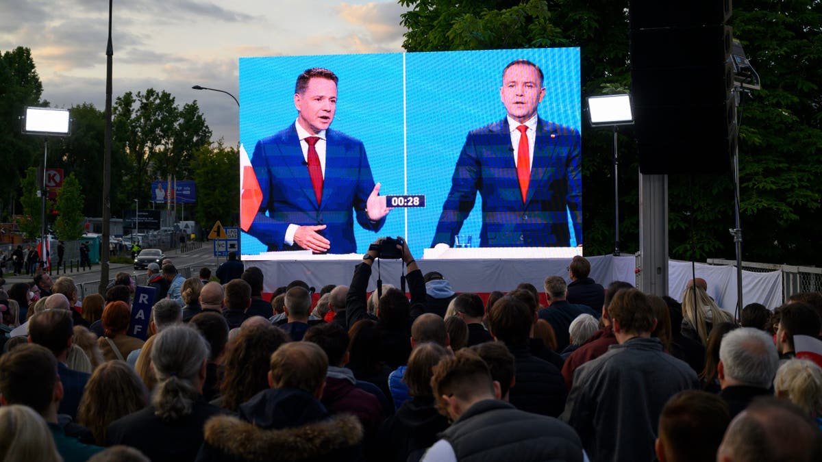 Warsaw's Mayor and presidential candidate Rafal Trzaskowski (left) and historian Karol Nawrocki appear on a screen during a presidential debate in Warsaw, Poland, on May 23, 2025.