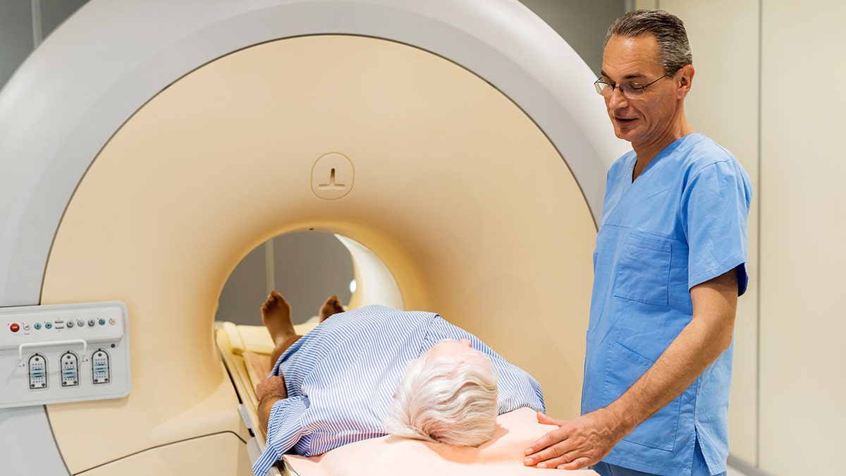Male radiologist is talking to a patient who is about to receive a medical scan for prostate cancer.