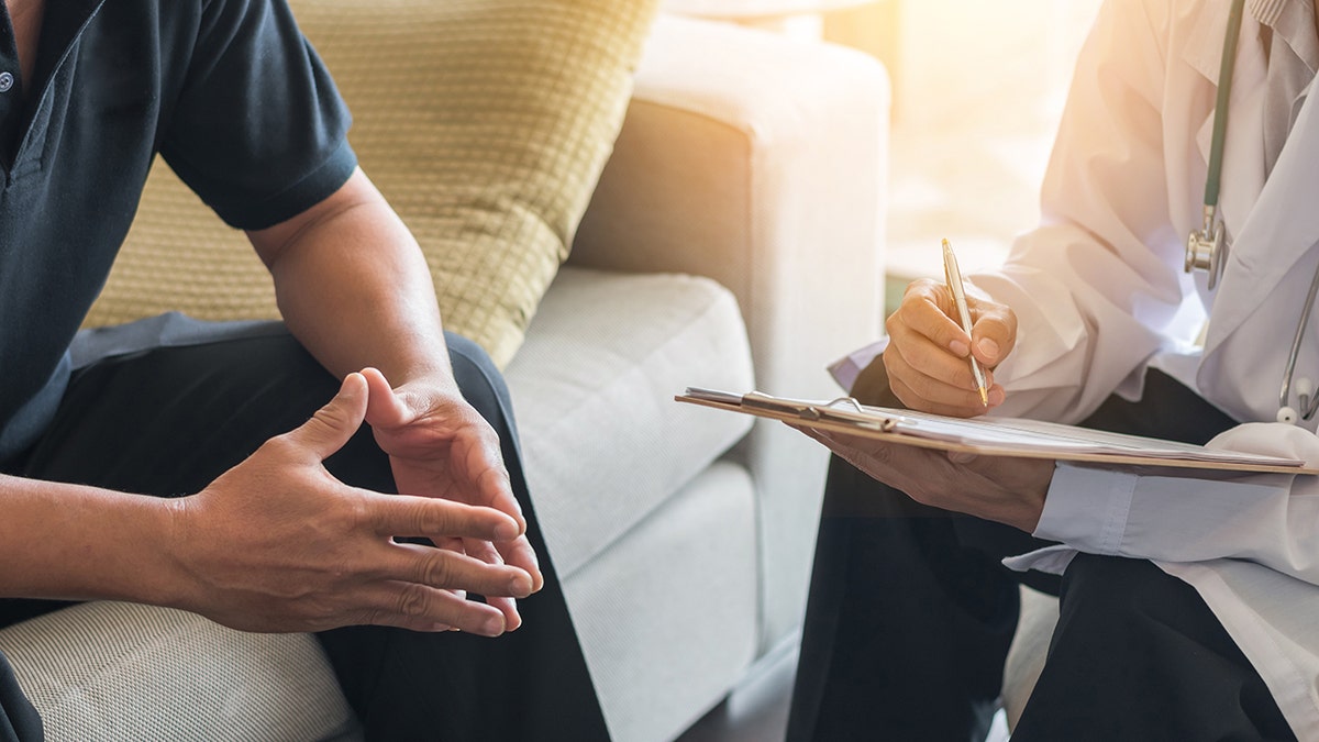 Doctor consulting male patient, working on diagnostic examination on men's health disease or mental illness, while writing on prescription record information document in clinic or hospital office. To be used in piece about prostate cancer screenings