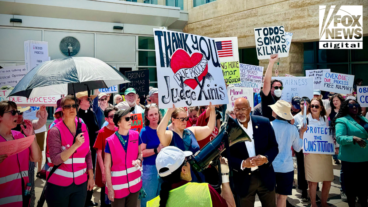 A crowd of demonstrators gathers outside the U.S. District Court in Greenbelt, Maryland, holding signs and chanting in support of Kilmar Abrego Garcia. Visible signs read