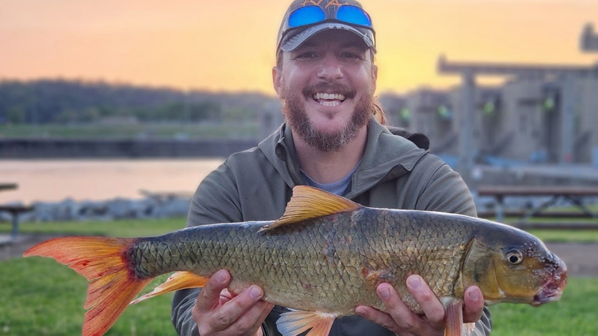 Man smiling holding large fish
