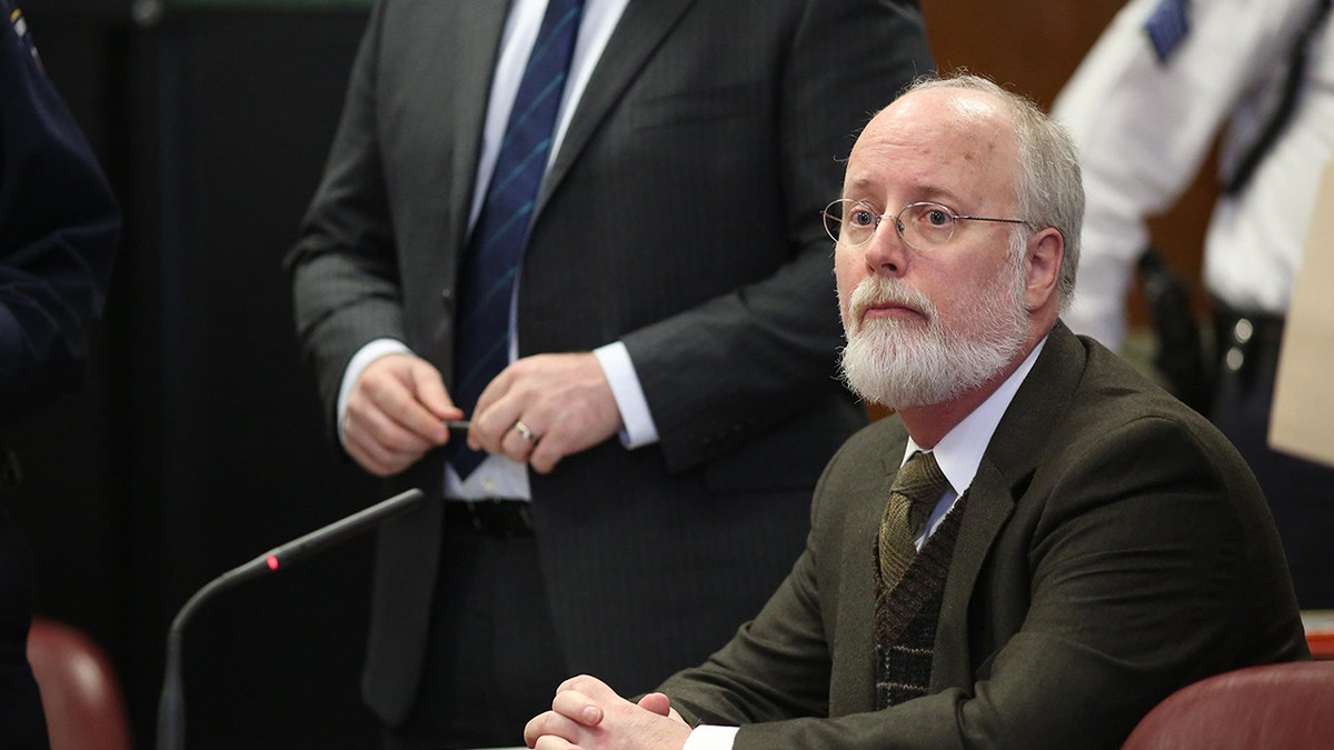 Robert Hadden sits behind a table