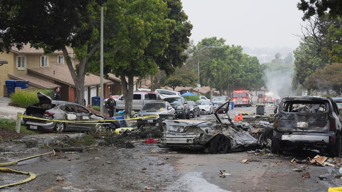 Authorities work the scene where a small plane crashed into a San Diego neighborhood.