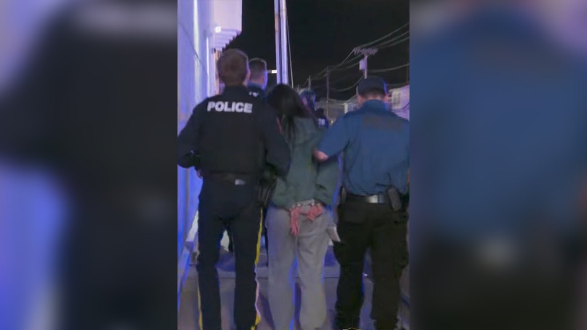 police escort cuffed man during night