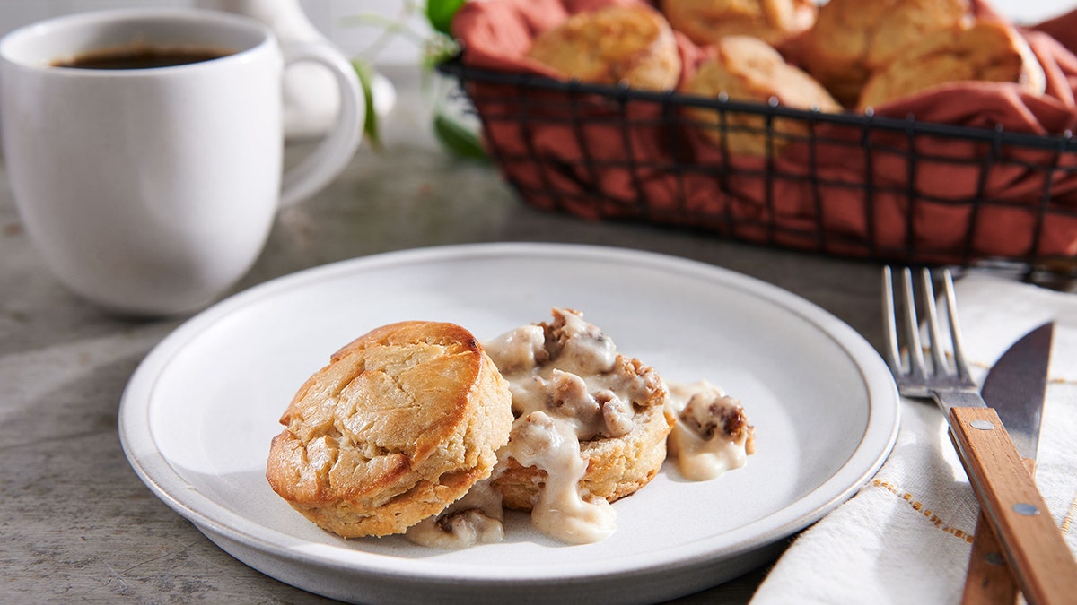 A southern biscuit made out of sorghum flour on a plate with coffee in the background.