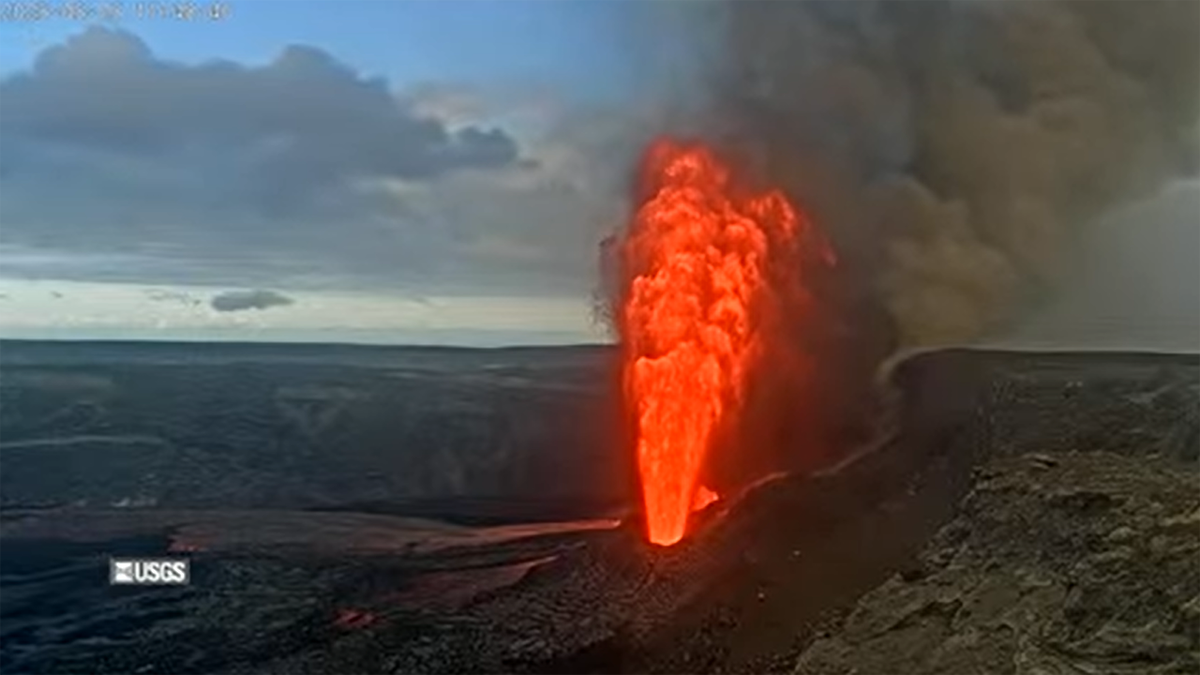 Geiser of orange lava after sunrise
