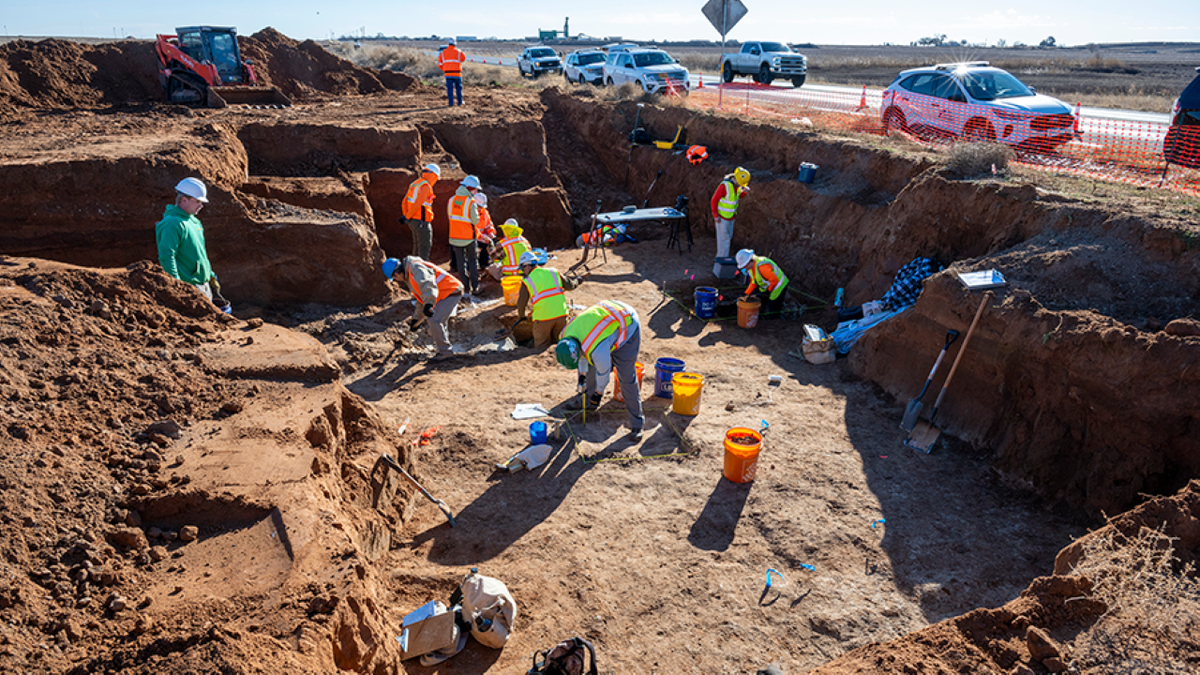 Archaeologists huddle together at site