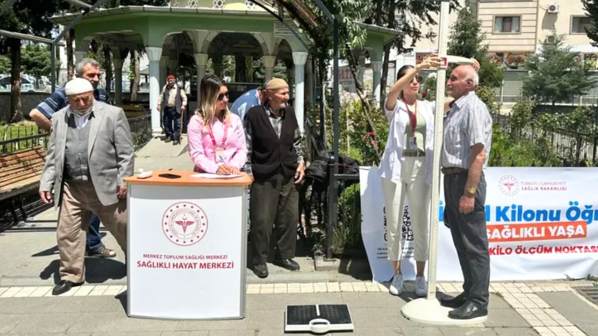 A man gets his height measured in public in Turkey.
