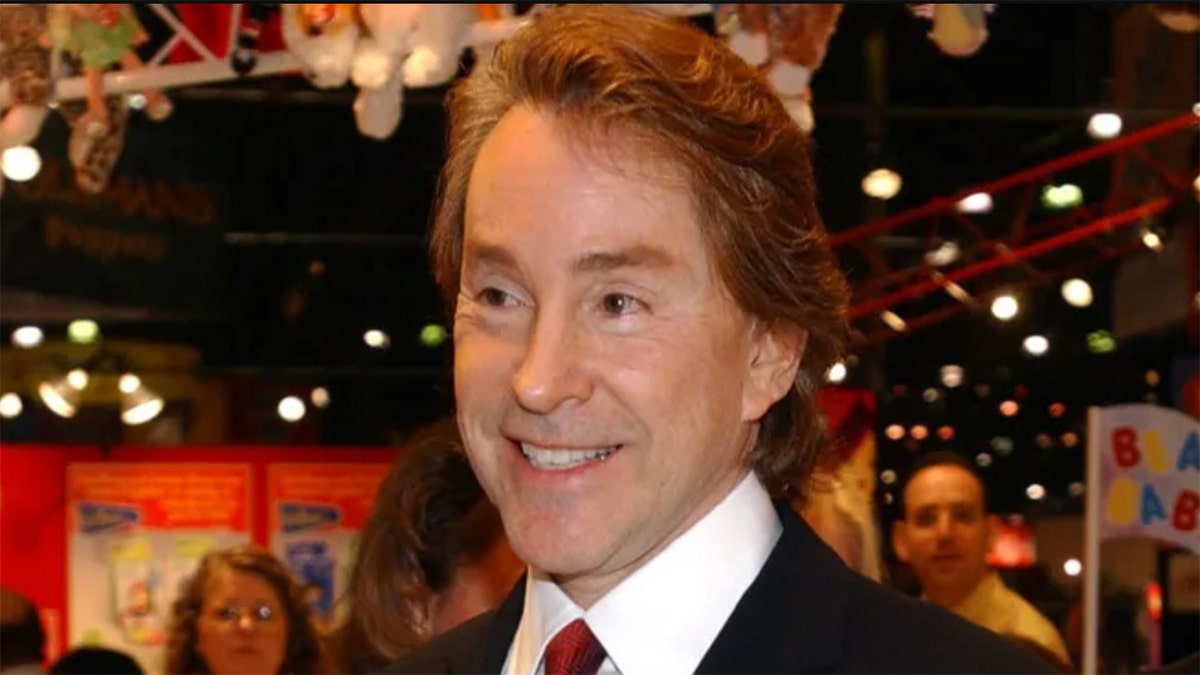 Ty Inc. CEO Ty Warner smiles in a red tie and black jacket