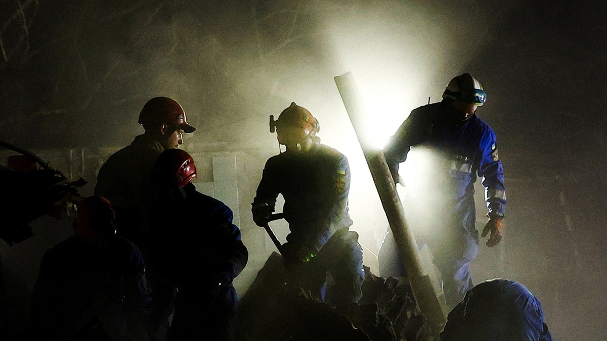 Rescuers work at the site of an apartment building hit by a Russian ballistic missile strike, in Kyiv