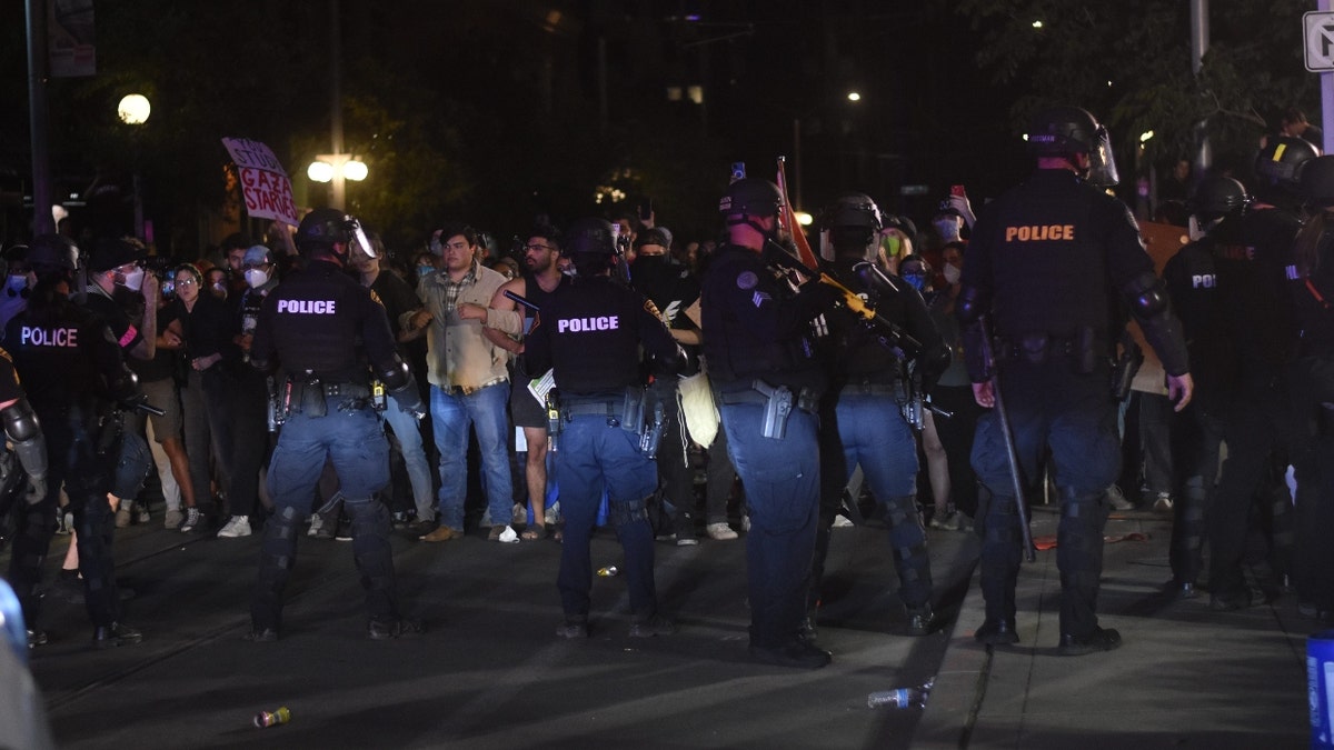 Law enforcement tear down an encampment that protesters had built on the University of Arizona campus and clash with protesters on Tucson street on May 1, 2024.
