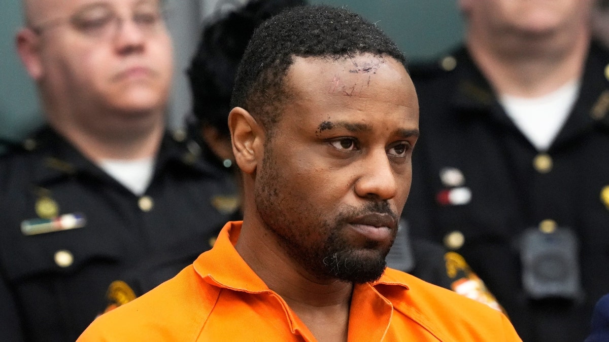 Rodney Hinton Jr. in court surrounded by police officers