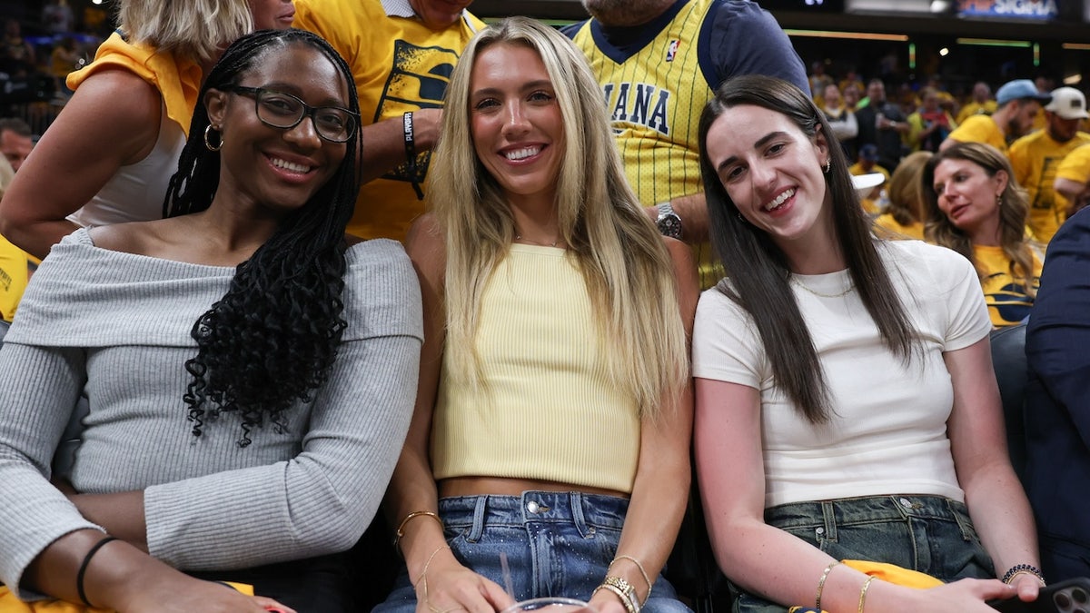 Indiana Fever players Aliyah Boston (left), Lexie Hull and Caitlin Clark are in attendance during game six of the eastern conference finals between the Indiana Pacers and the New York Knicks for the 2025 NBA Playoffs at Gainbridge Fieldhouse.