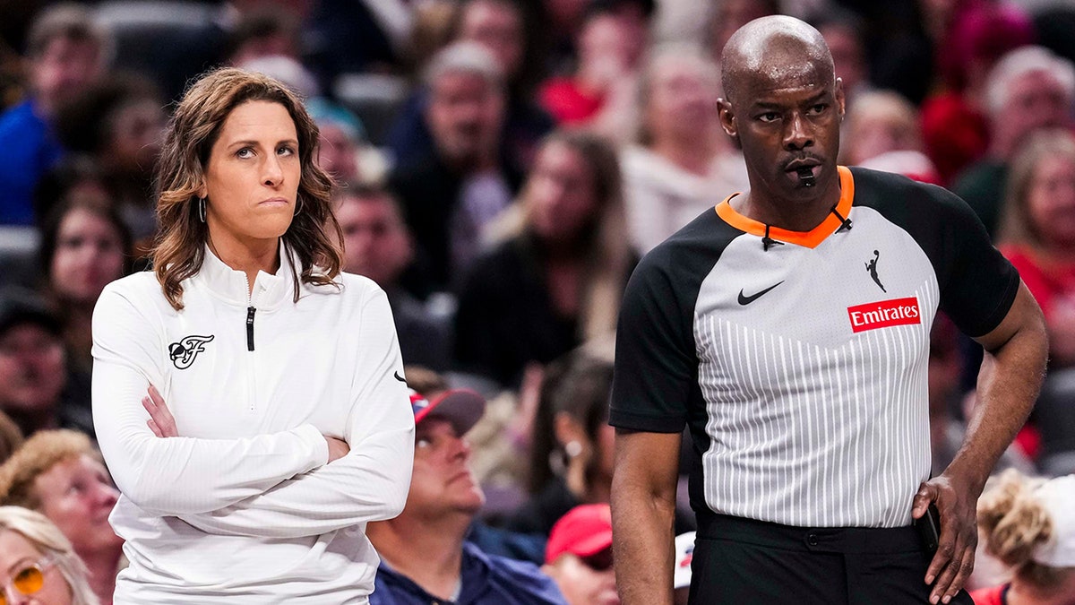Stephanie White stands next to WNBA ref
